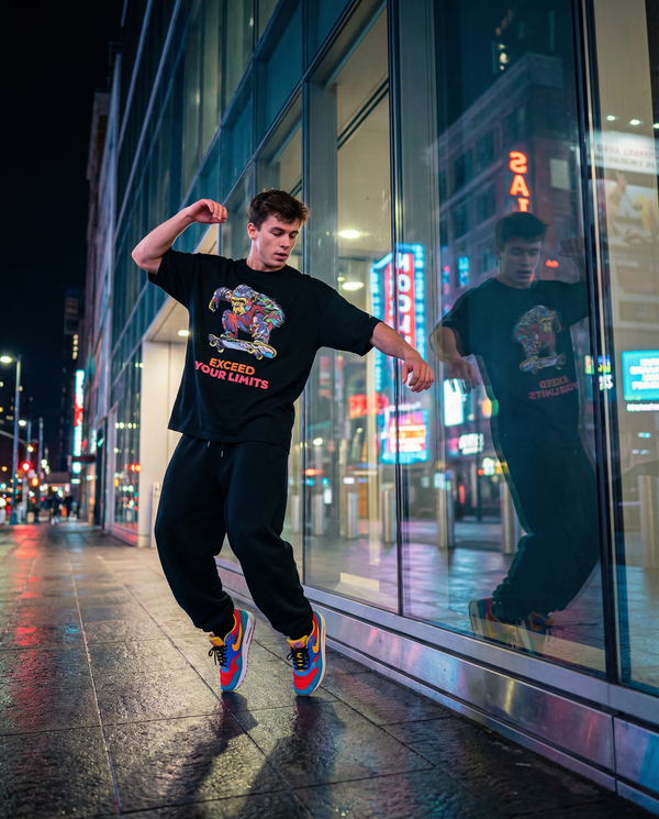 Style Sample01  Oversized T-shirt × Black sweat pants  オーバーサイズTシャツに ブラックのスウェットパンツを合わせた ストリートアクティブスタイル。  カラフルなスニーカーをアクセントに、 夜の街でも映える ダイナミックなコーデ。  動きやすく、自由に。 日常にアートを。 保存してコーデの参考に ↗