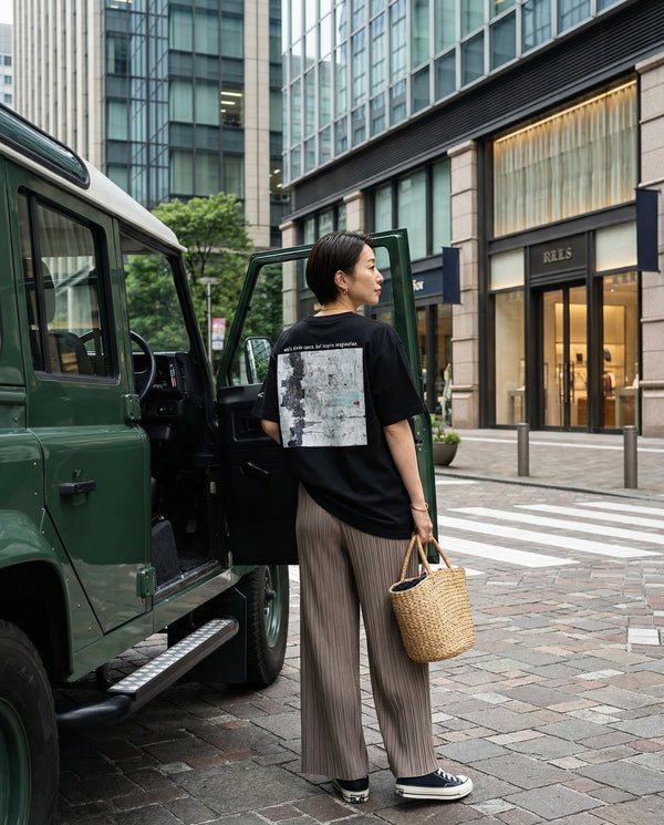 Style Sample01  Oversized T-shirt × Pleated wide pants  バックプリントのアートTシャツに トープカラーのプリーツワイドパンツを合わせた 都会的でリラックスしたスタイル。  黒のスニーカーと ストロートートバッグで ショッピングにも似合う軽やかなバランスに。  丸の内の街並みにも馴染む 大人のシティカジュアル。  日常にアートを。 保存してコーデの参考に ↗